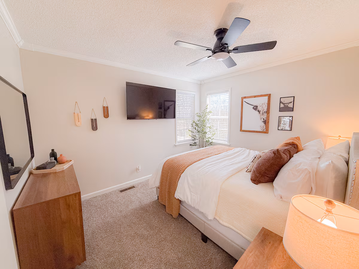 Primary bedroom with king bed, ceiling fan, and gallery wall