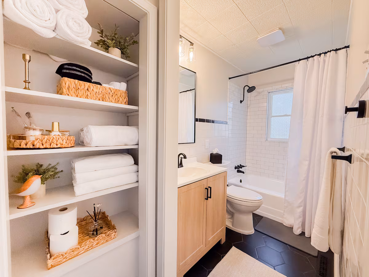 Bathroom with subway tile tub-shower and open linen shelving
