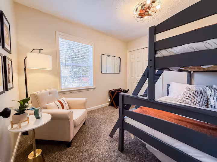 Second bunk room with reading chair and gallery wall