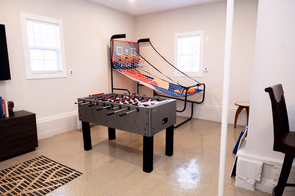 Foosball table and arcade basketball hoops in the game room